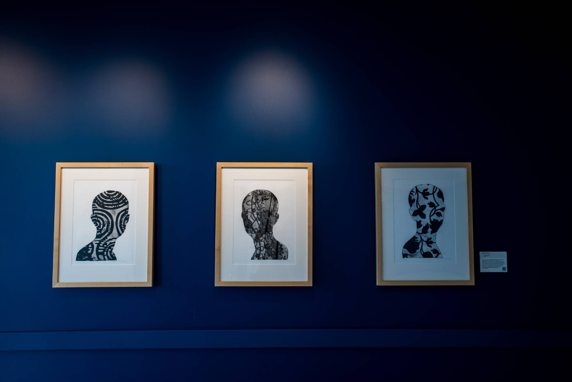 artwork of heads displayed on a wall